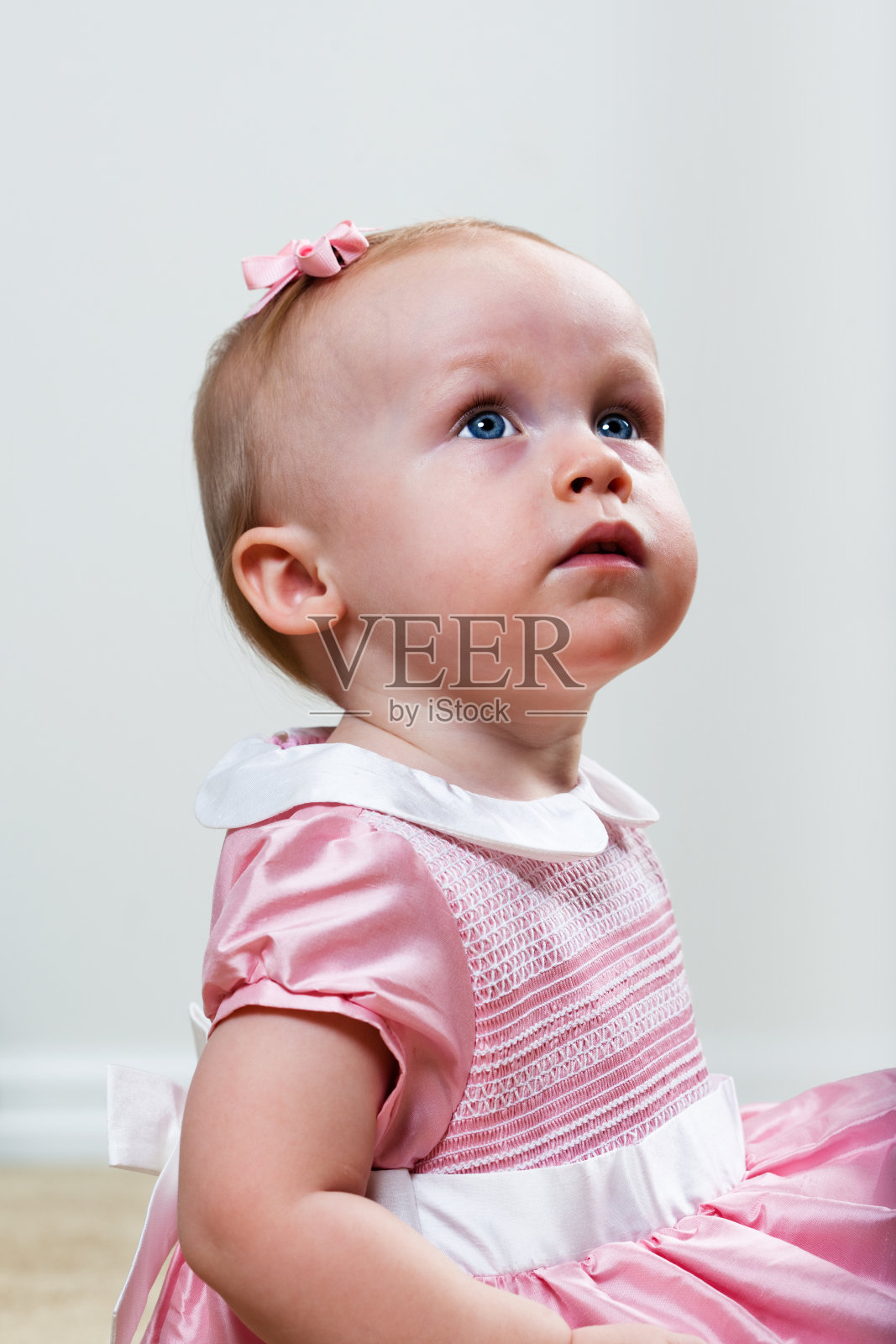 粉红色的小孩抬头看照片摄影图片