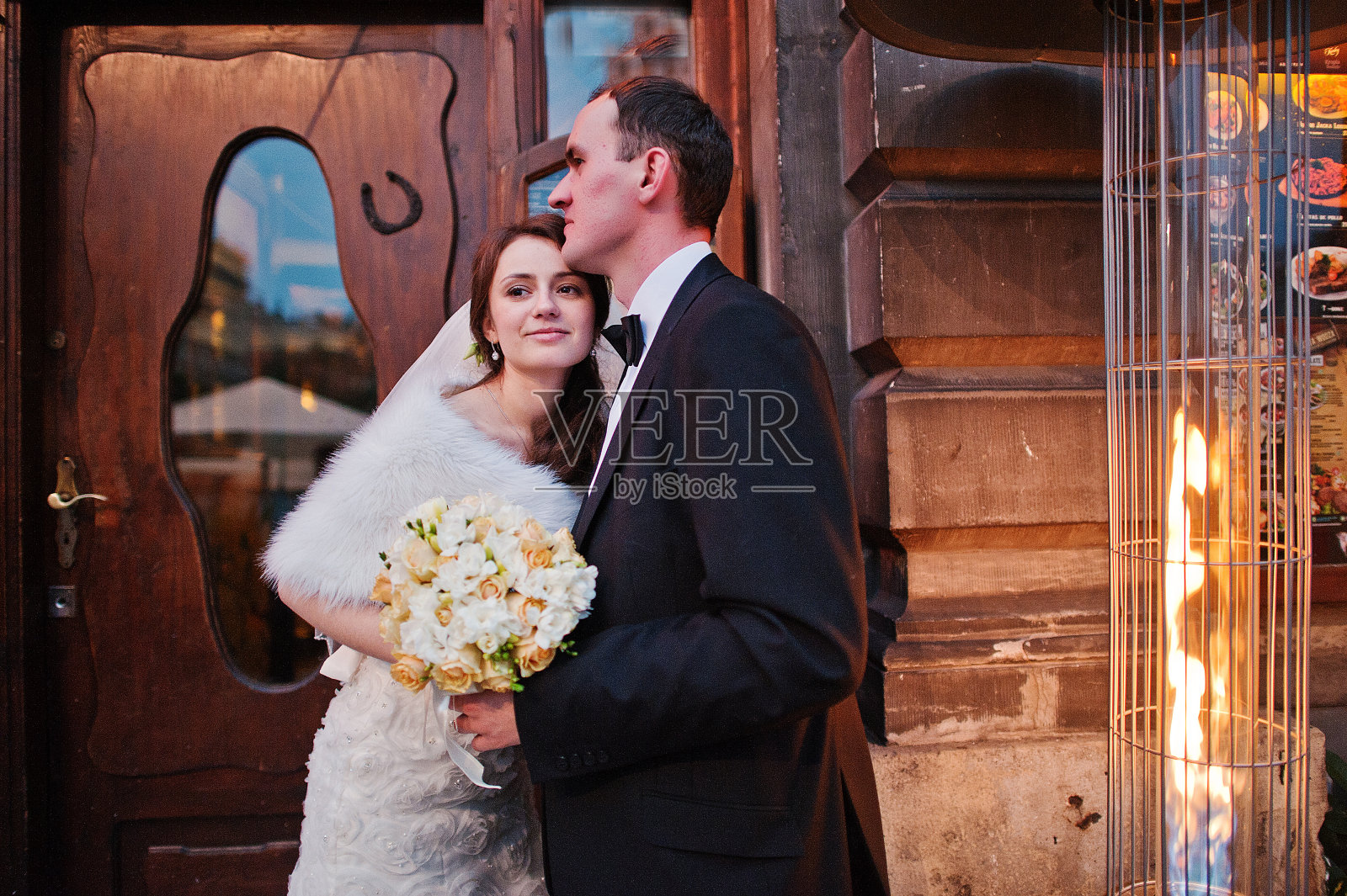 在波兰克拉科夫的街道上，年轻的优雅和热情的新婚夫妇相爱照片摄影图片