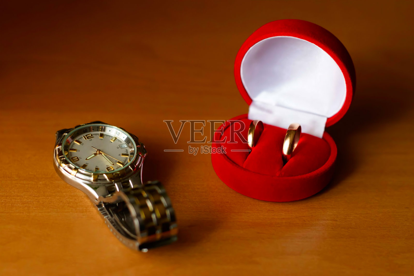 结婚戒指放在盒子里，手表放在桌子上照片摄影图片