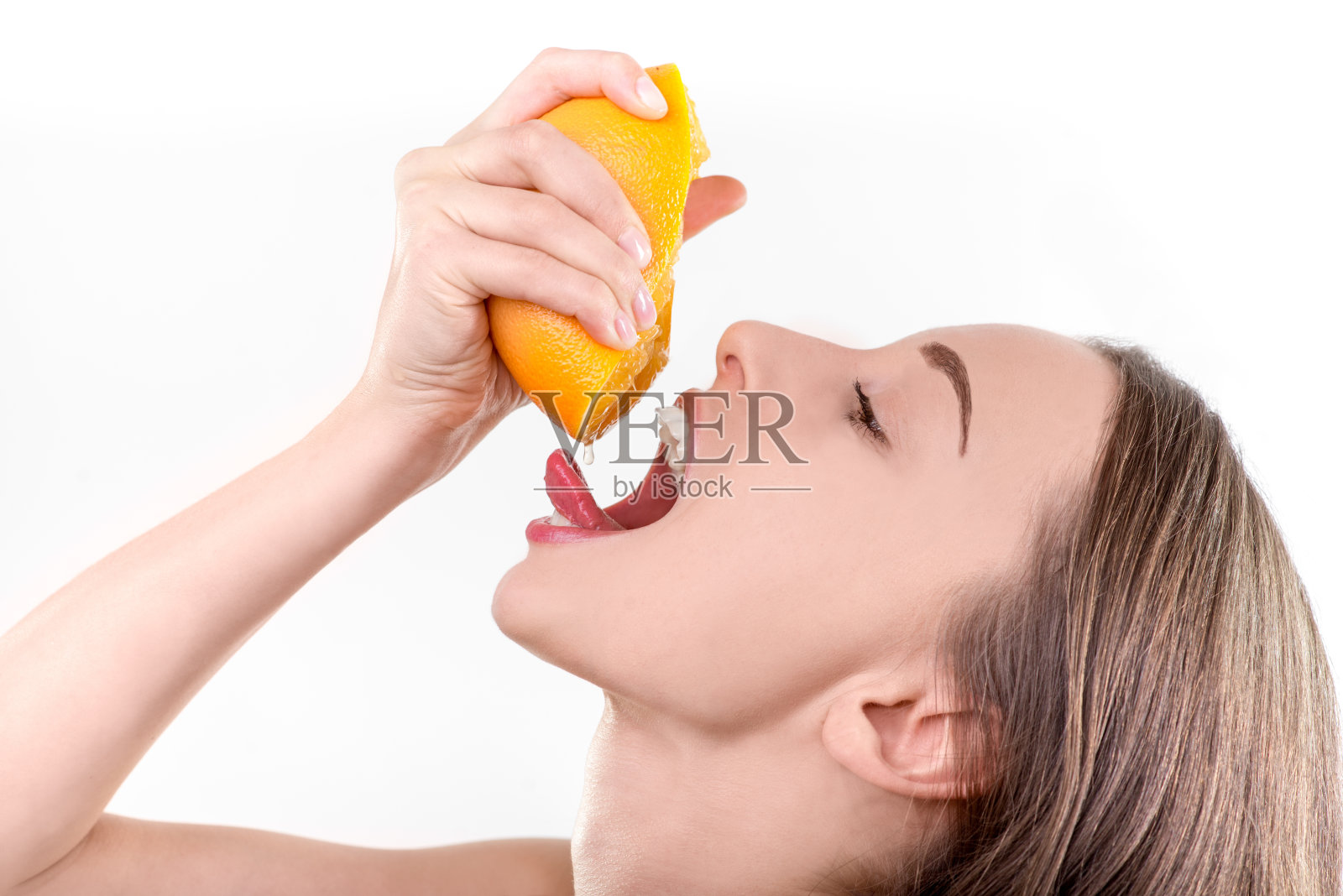 年轻女孩压榨和饮用橙汁照片摄影图片