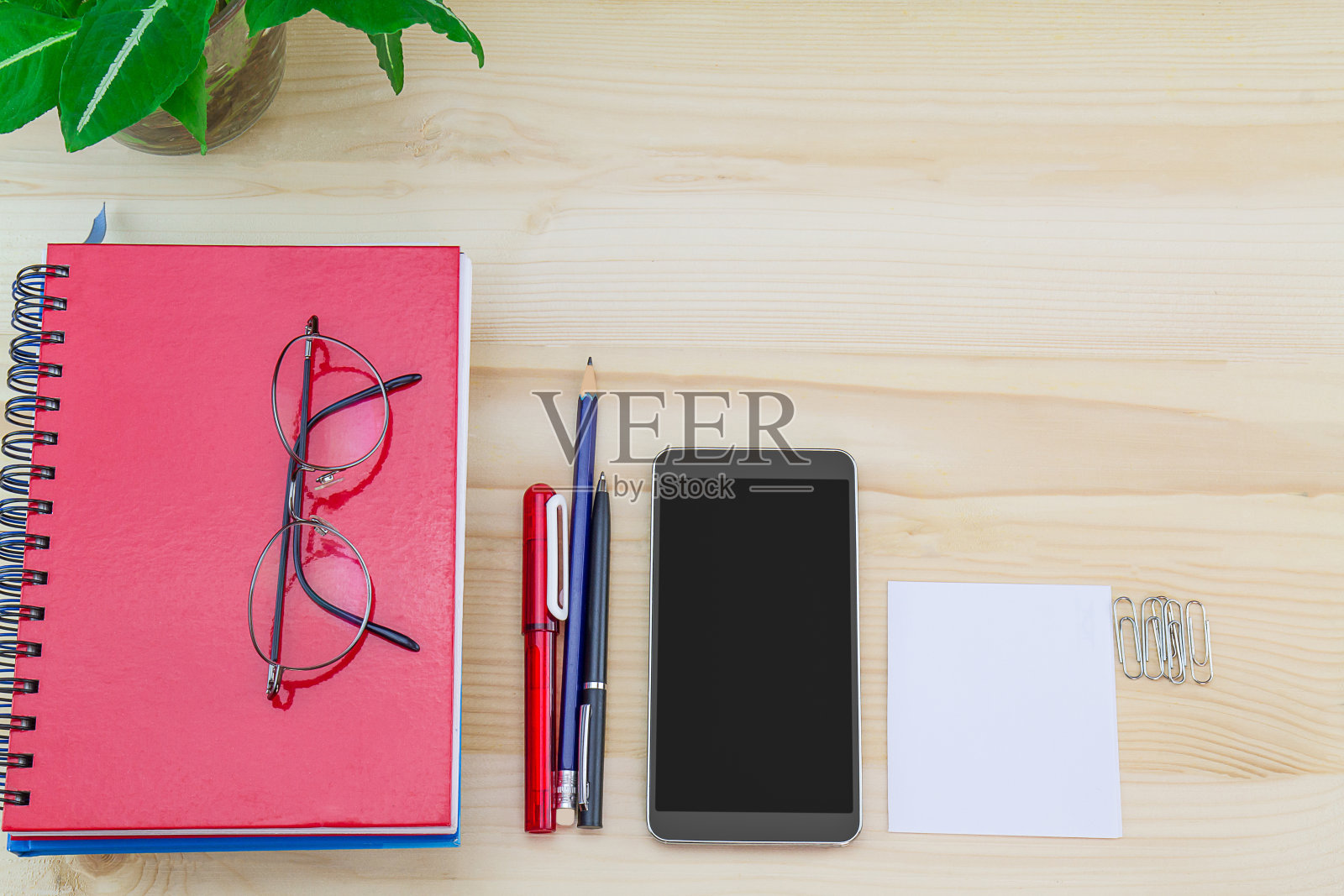 智能手机，眼镜，笔记本，古董木桌上的文具照片摄影图片