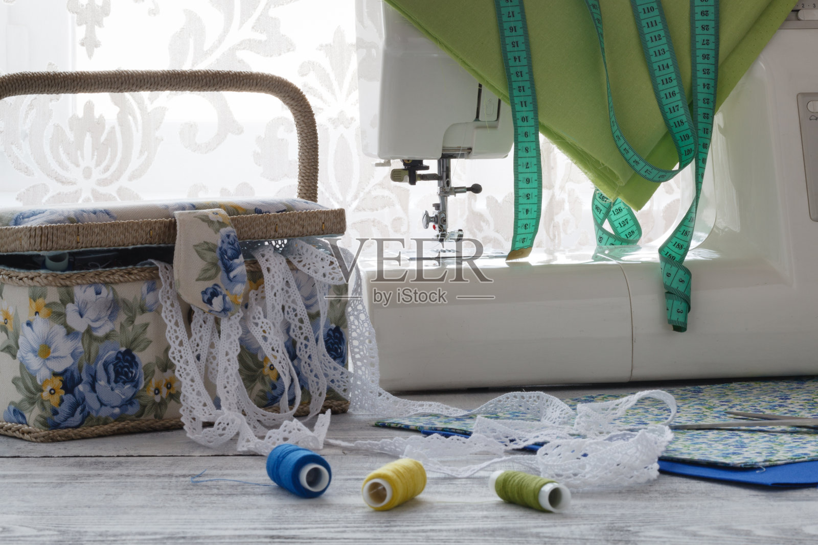有许多缝纫用具的缝纫机放在一张木桌上照片摄影图片
