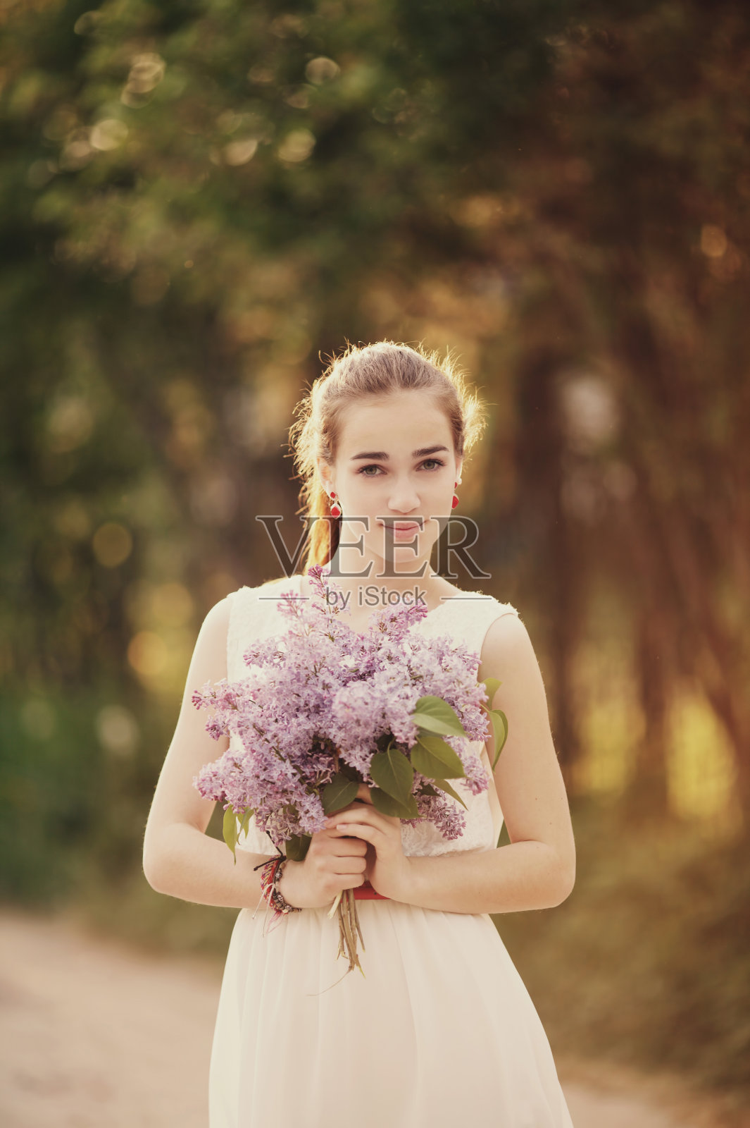 拿着一束丁香的女孩照片摄影图片