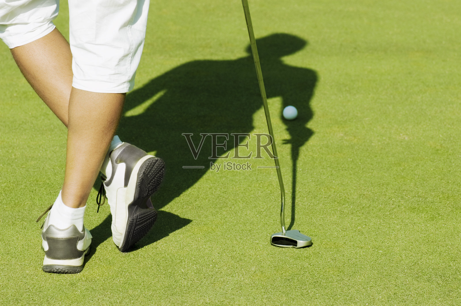 男子站在果岭上，低处照片摄影图片