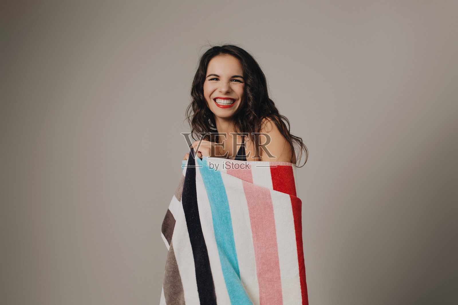 漂亮的年轻女士在泳衣拿着彩色毛巾照片摄影图片