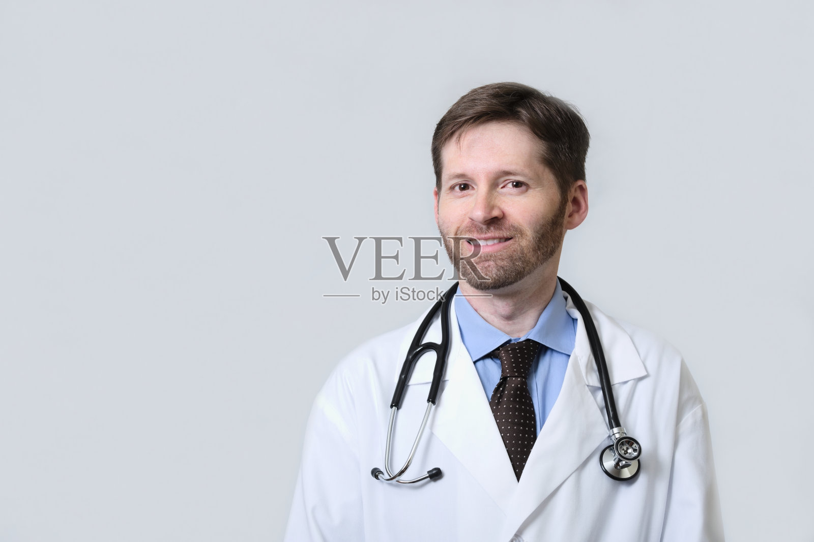 带着胡子微笑的医生戴着听诊器照片摄影图片