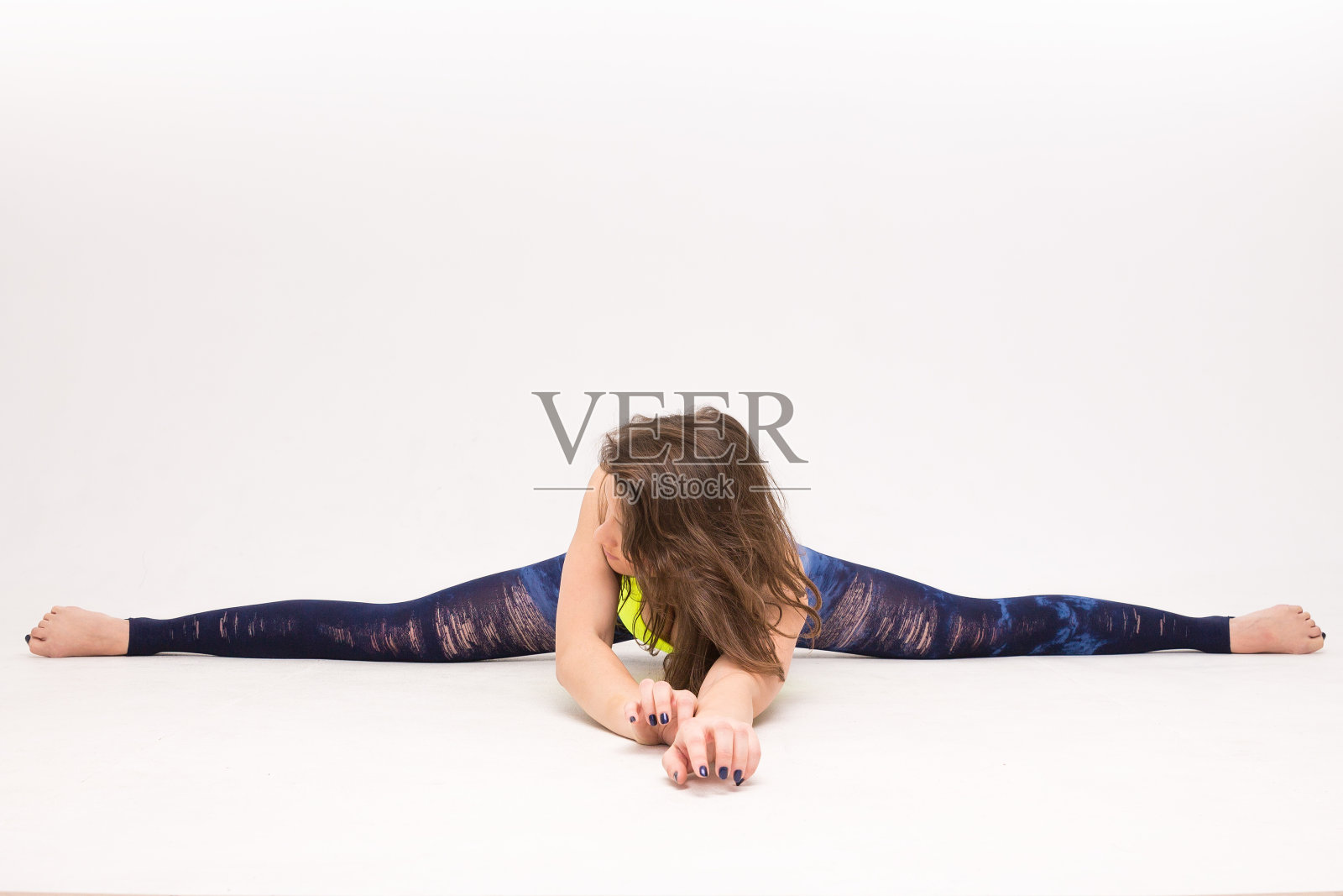 年轻女人坐在劈叉上照片摄影图片