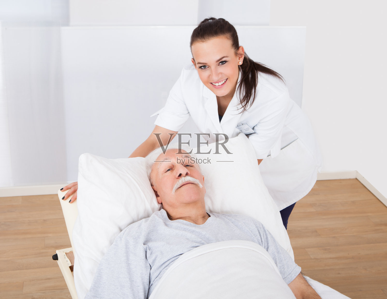 快乐的医生和老男人躺在床上照片摄影图片