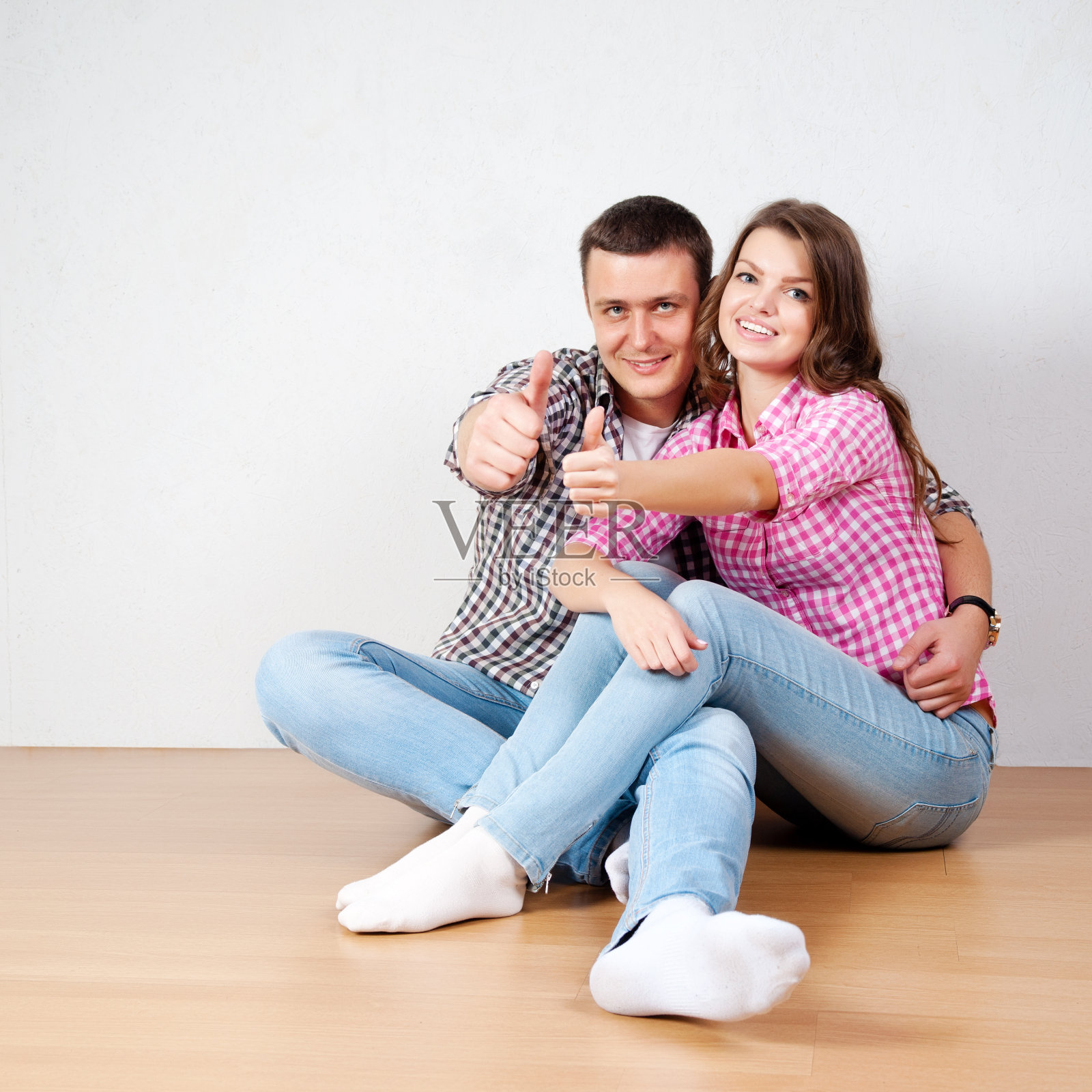 美丽的赤足青年情侣穿着休闲牛仔裤坐着照片摄影图片