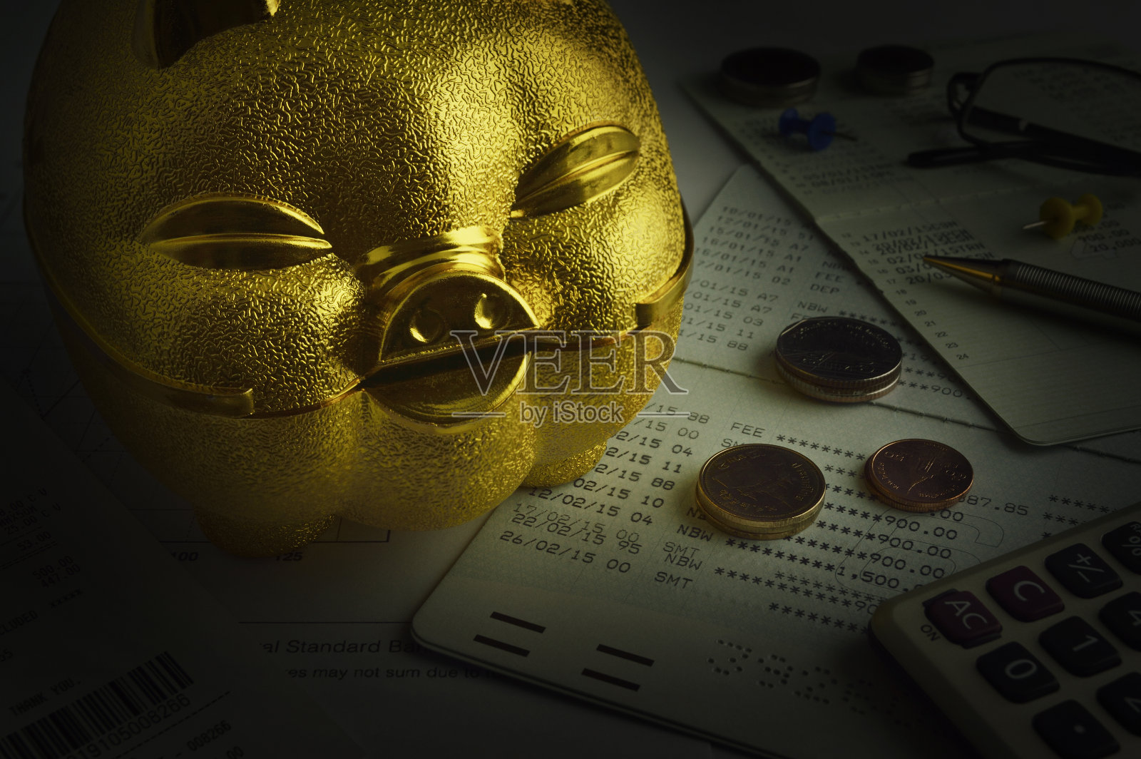 储蓄存折上有硬币的金存钱罐照片摄影图片