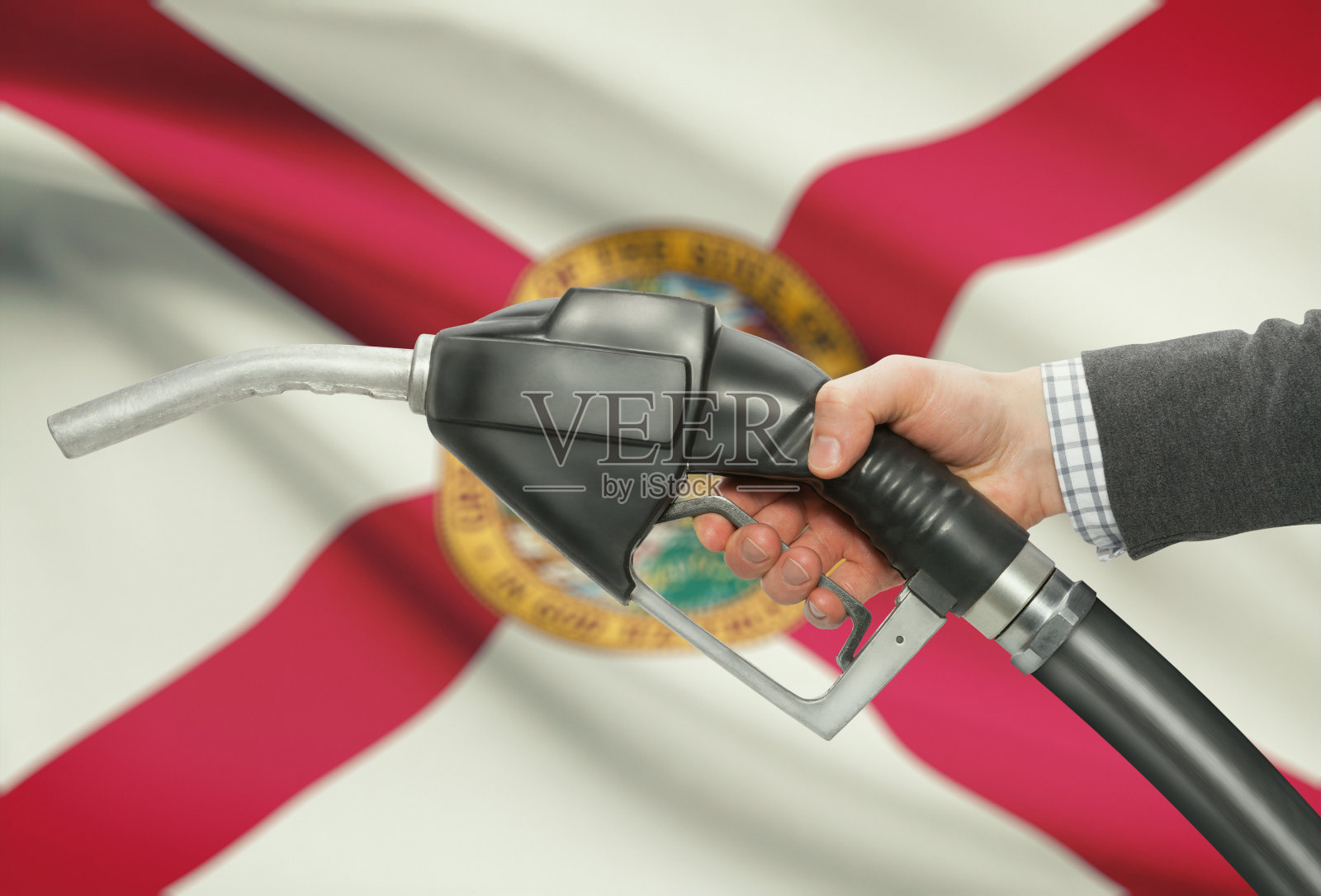 燃油泵喷嘴手与美国各州的旗帜在背景-佛罗里达照片摄影图片