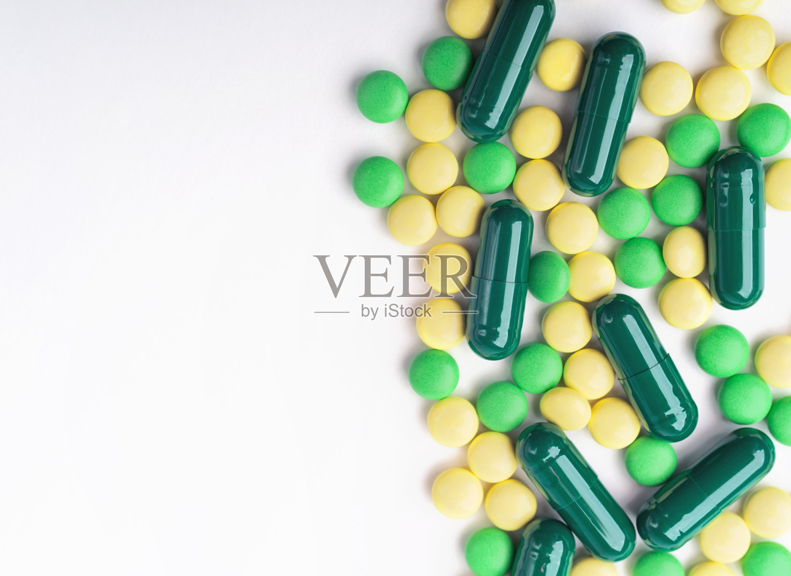 一堆黄色和绿色的药片和胶囊照片摄影图片