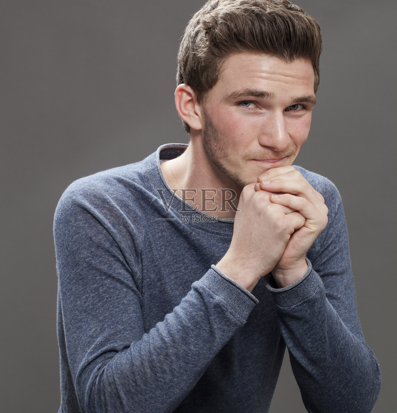 微笑着诱惑的年轻男学生，脸颊绯红照片摄影图片