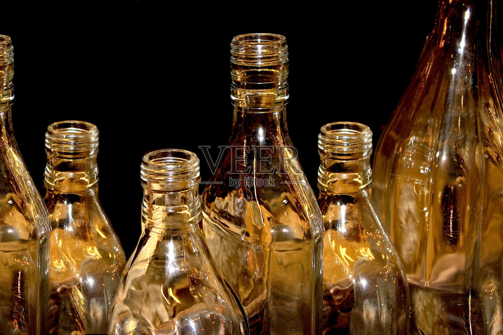 空瓶子与金色的反光与黑色的背景照片摄影图片