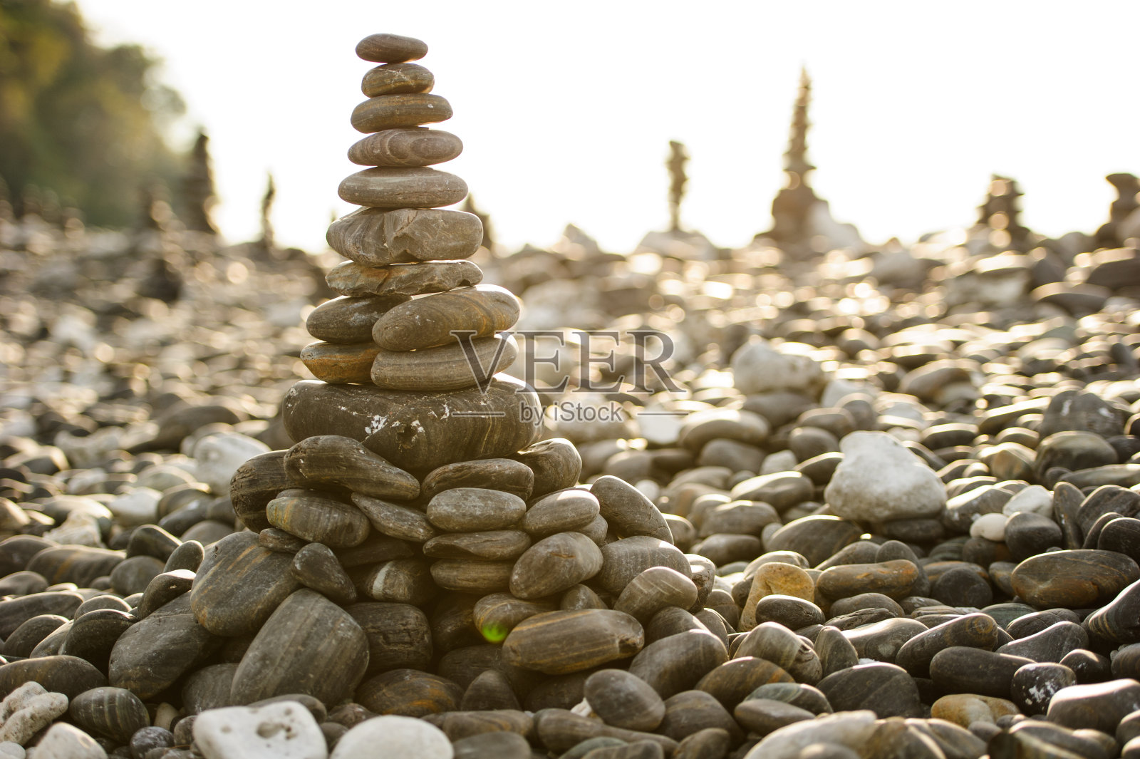 以海滩和大海为背景的堆叠的石头照片摄影图片