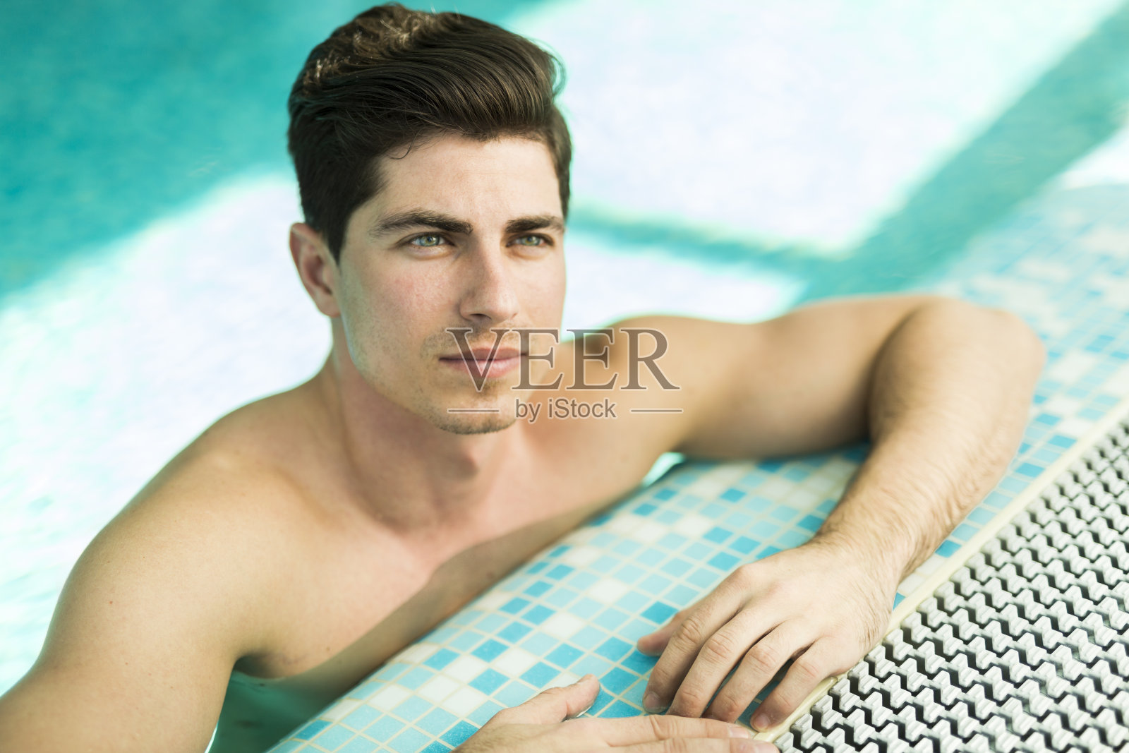 游泳池里的帅哥照片摄影图片