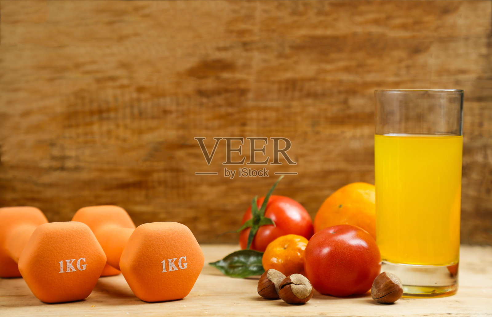 哑铃，橙汁，木桌上的水果和坚果，运动和健康的生活方式概念照片摄影图片