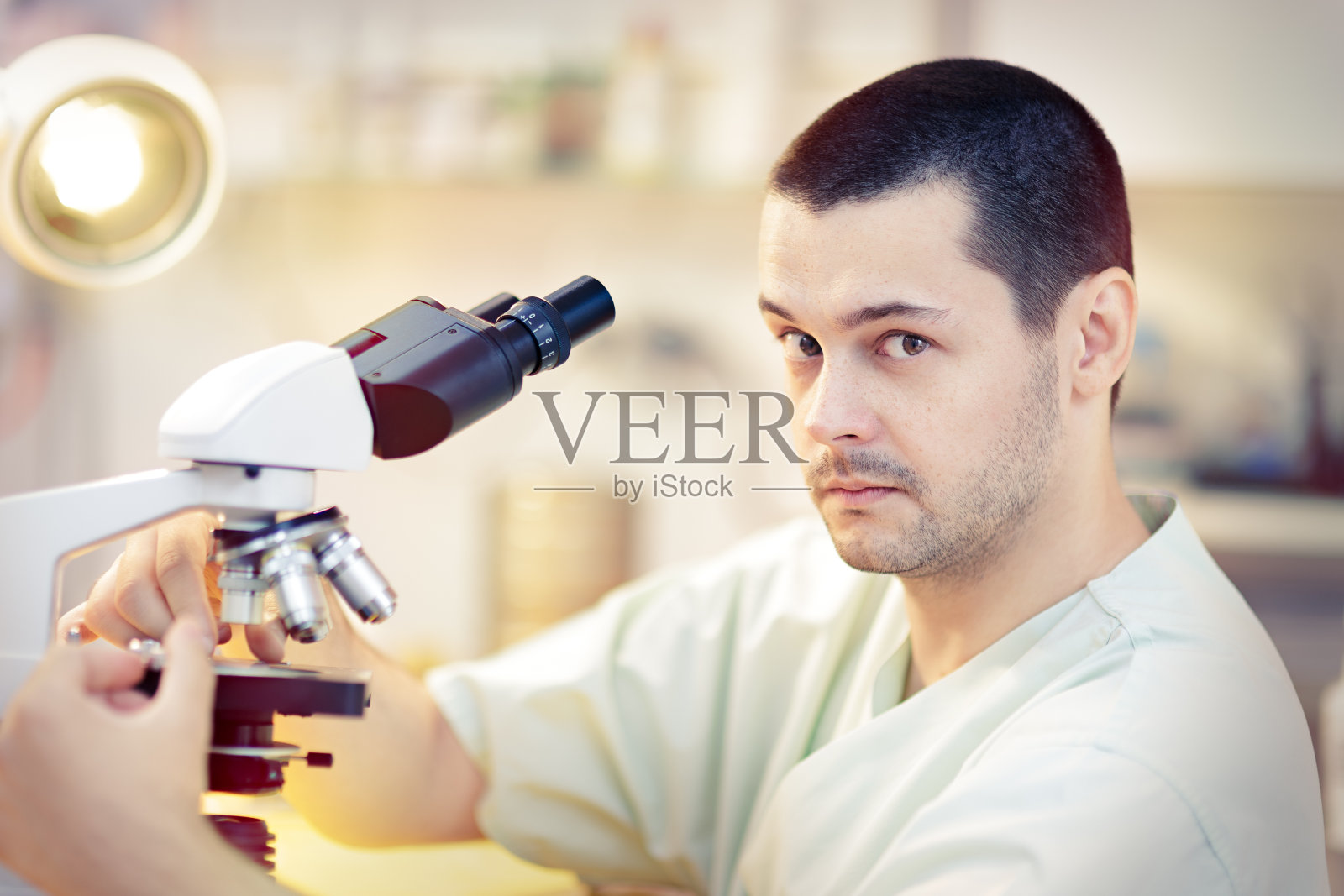 有趣的年轻男性科学家与显微镜照片摄影图片