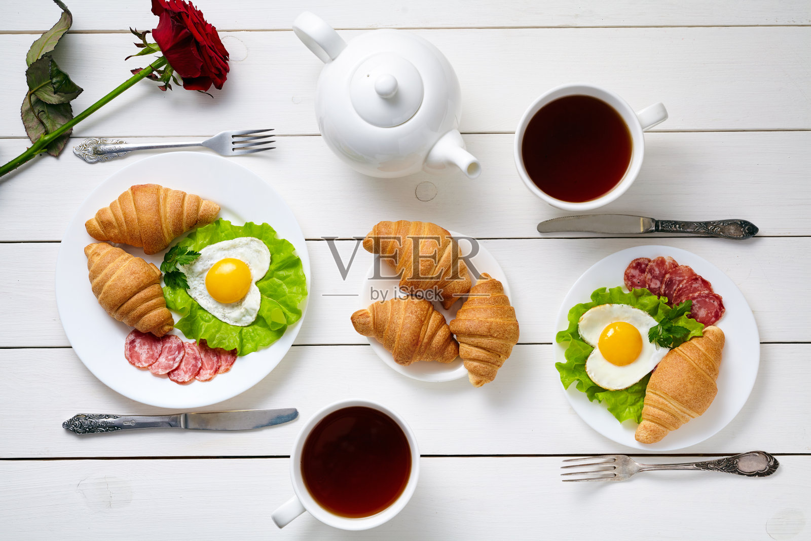 浪漫的双人早餐，心形的鸡蛋，沙拉，牛角面包照片摄影图片