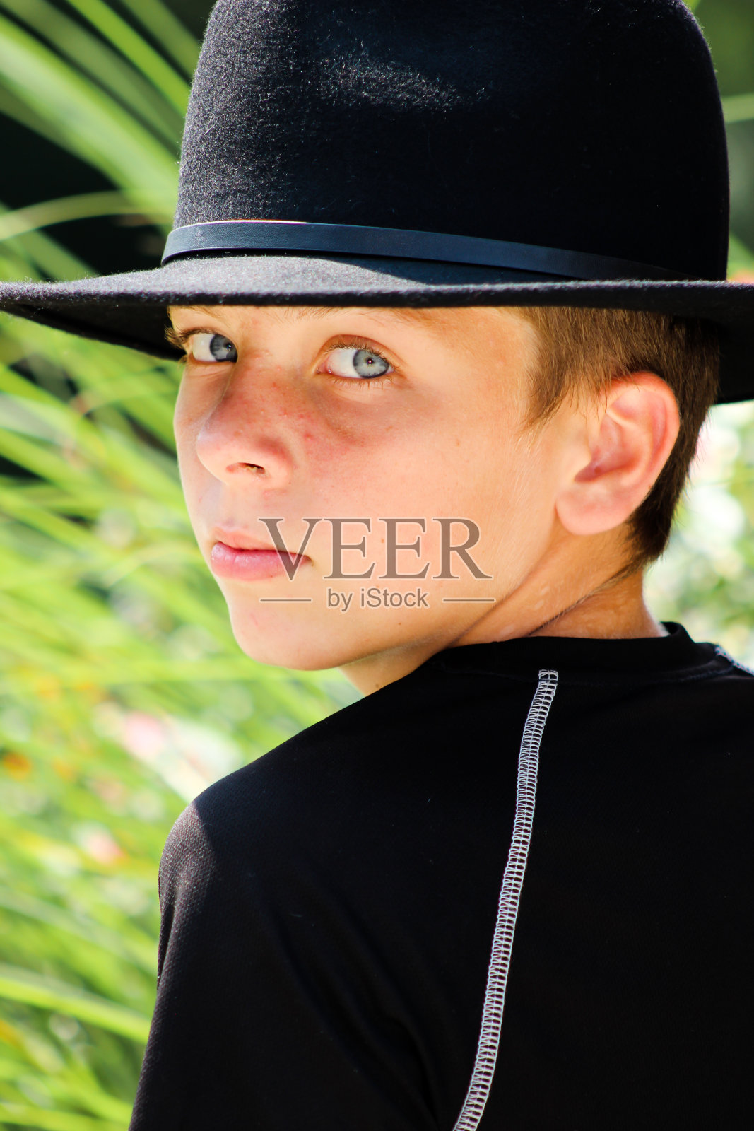 蓝眼睛的男孩回头看照片摄影图片