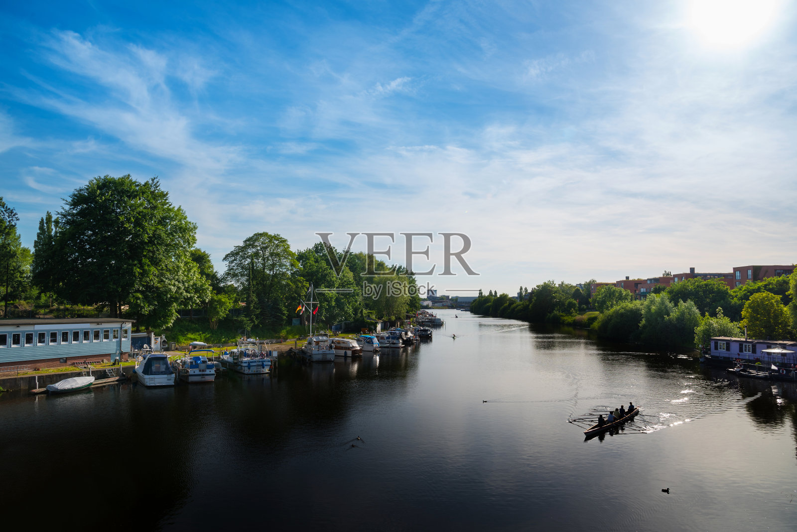 夏日蓝天下的德国汉堡，现代化的公寓楼和河上的船只照片摄影图片