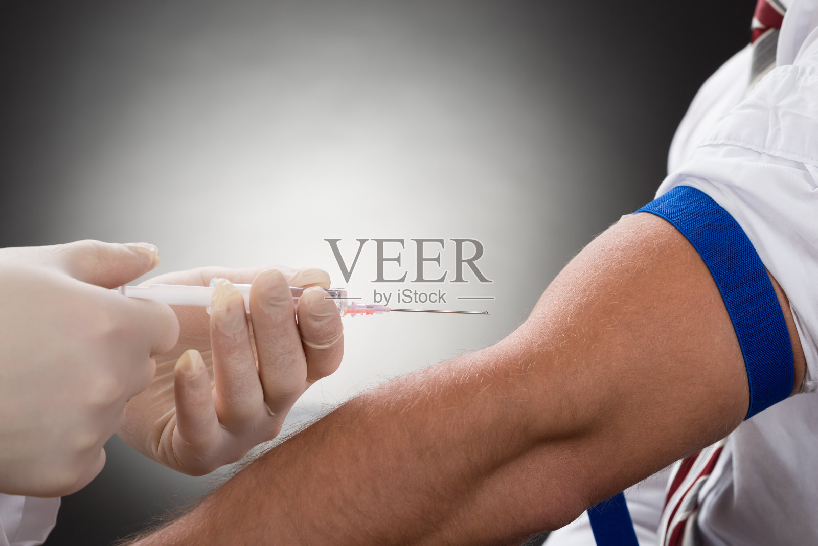 医生在病人手臂上注射注射器照片摄影图片