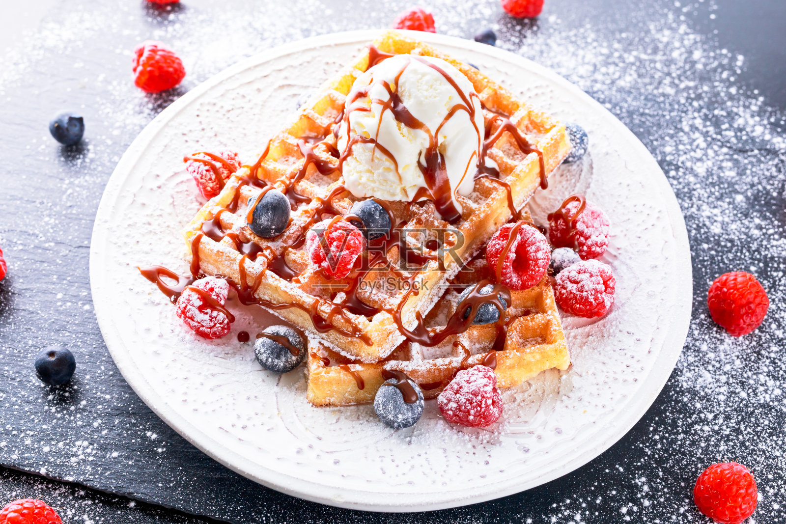 比利时华夫饼配冰淇淋，巧克力酱和新鲜浆果。照片摄影图片