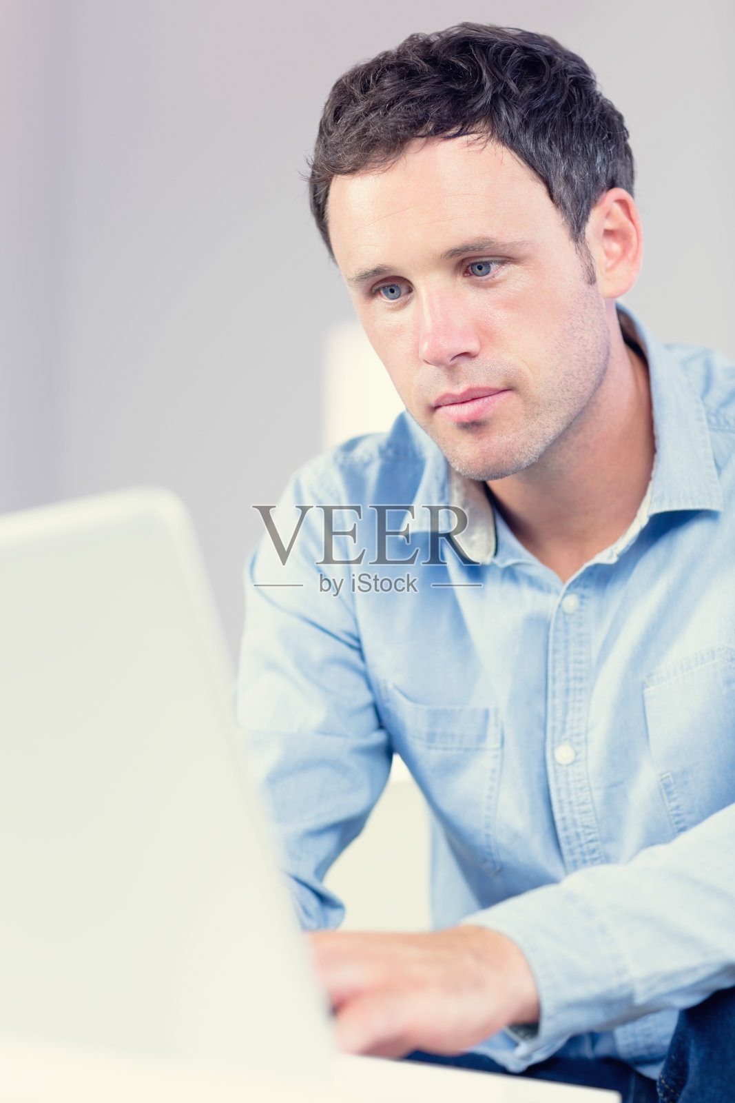 有魅力的休闲男人在看笔记本电脑照片摄影图片