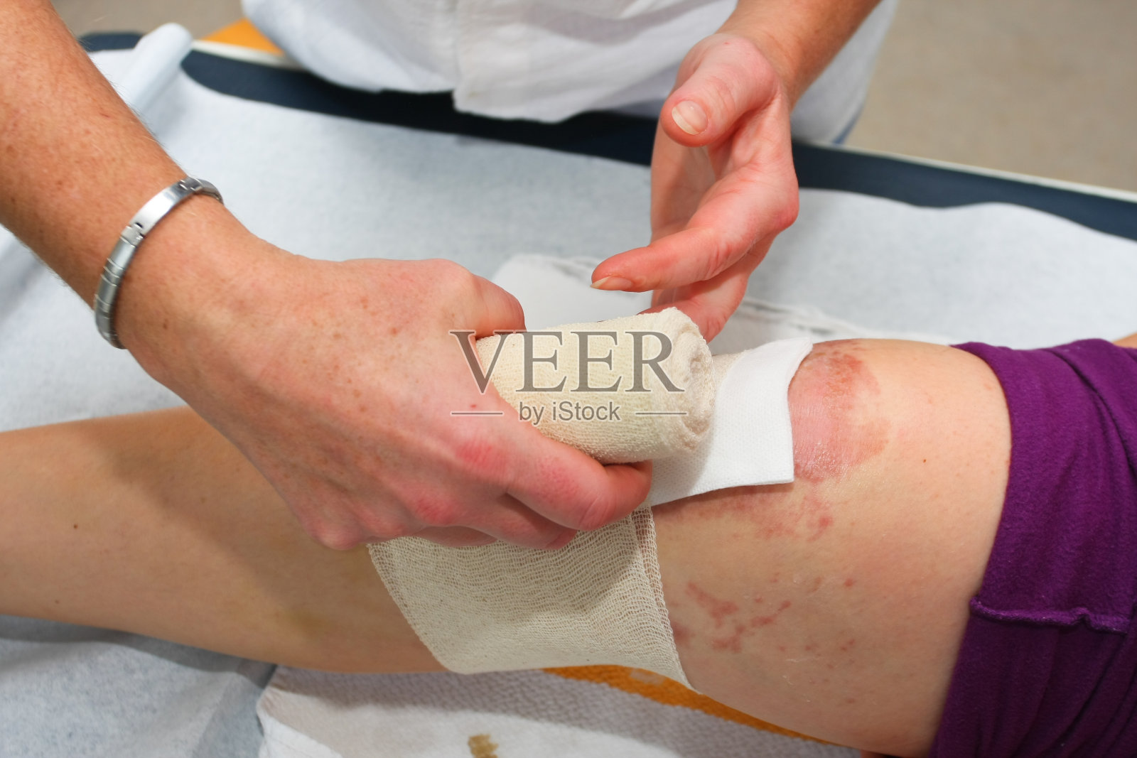 护士为膝盖手术后的病人更换绷带照片摄影图片