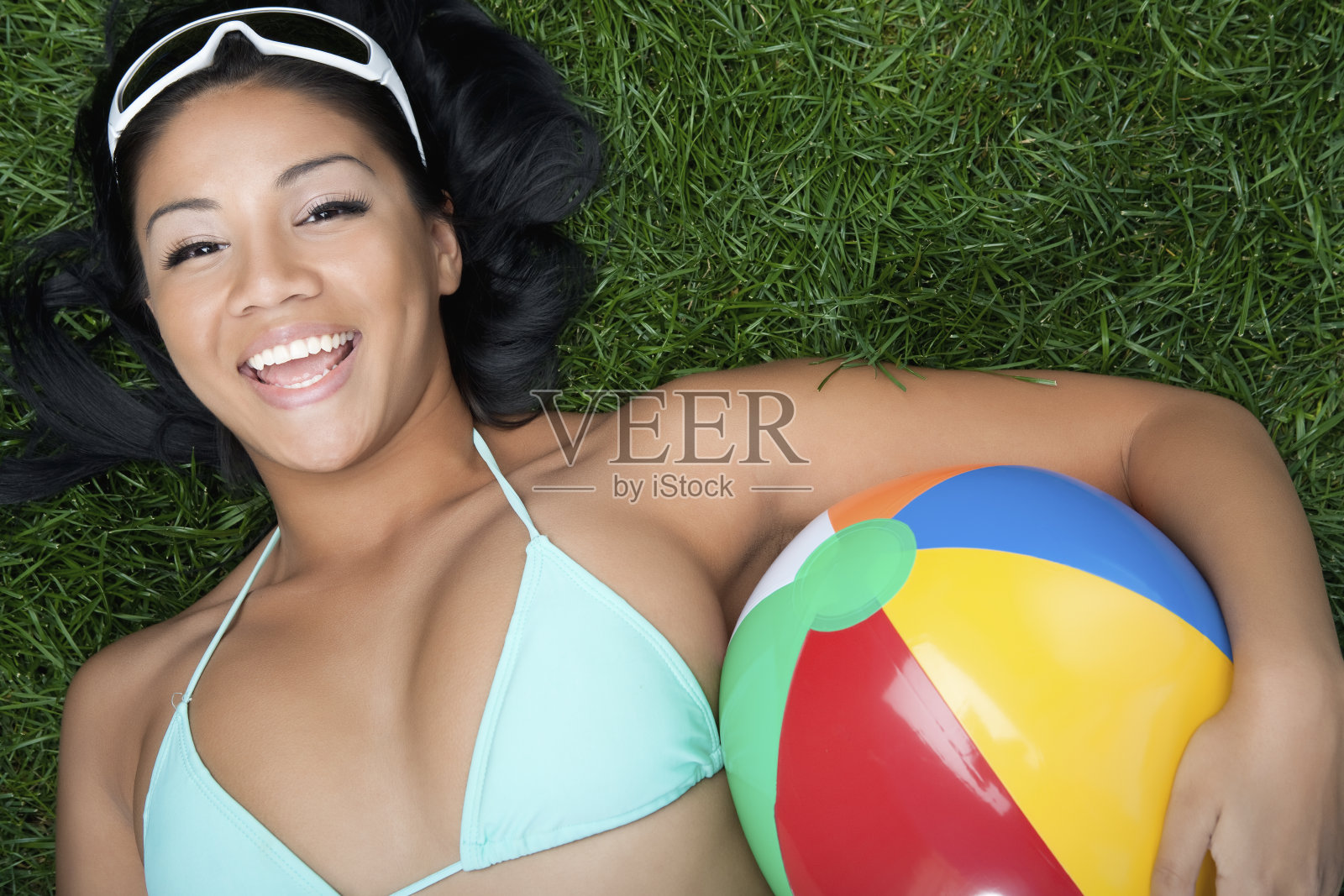 西班牙比基尼美女抱着沙滩球照片摄影图片