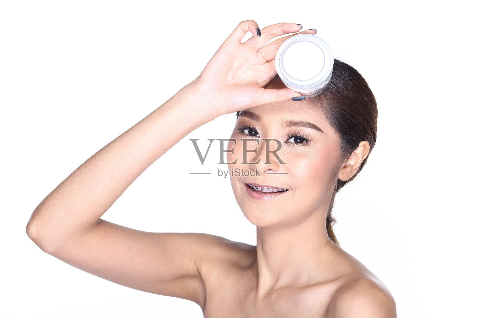 年轻的微笑女性拿着一个白色的空白圆瓶化妆品包装产品照片摄影图片