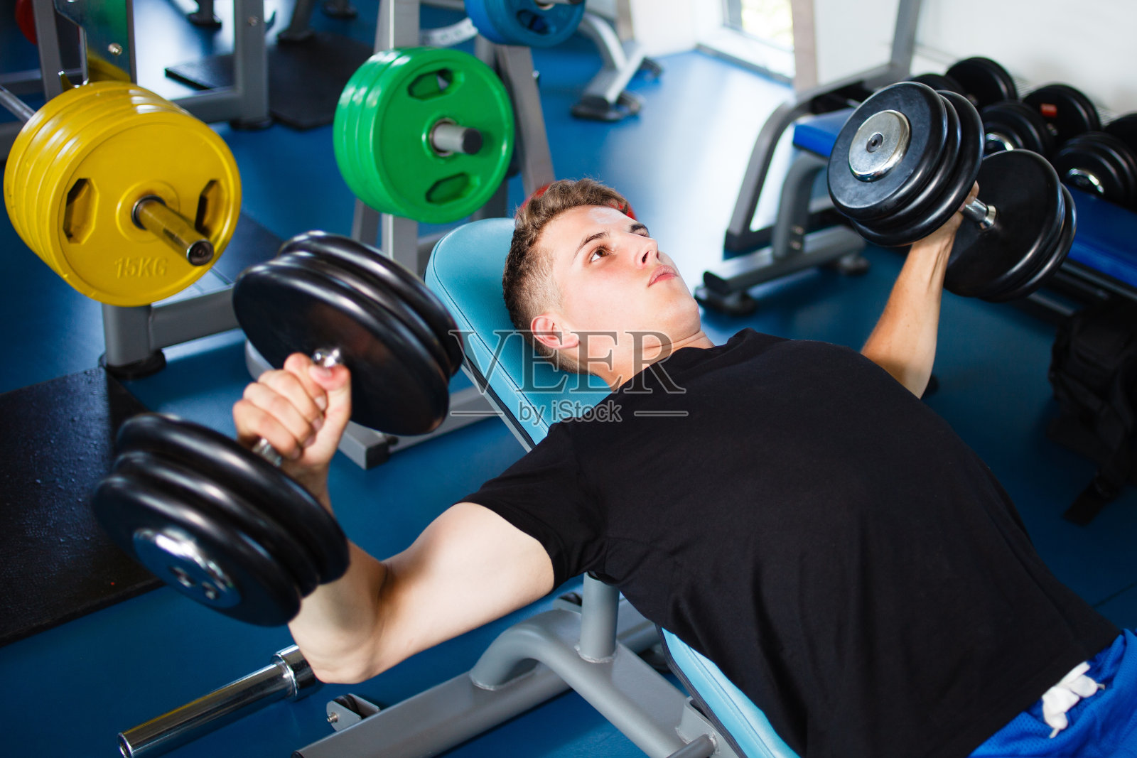 在健身房用哑铃锻炼照片摄影图片