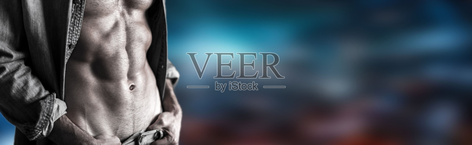 穿着灰色敞开衬衫的肌肉发达的年轻人照片摄影图片