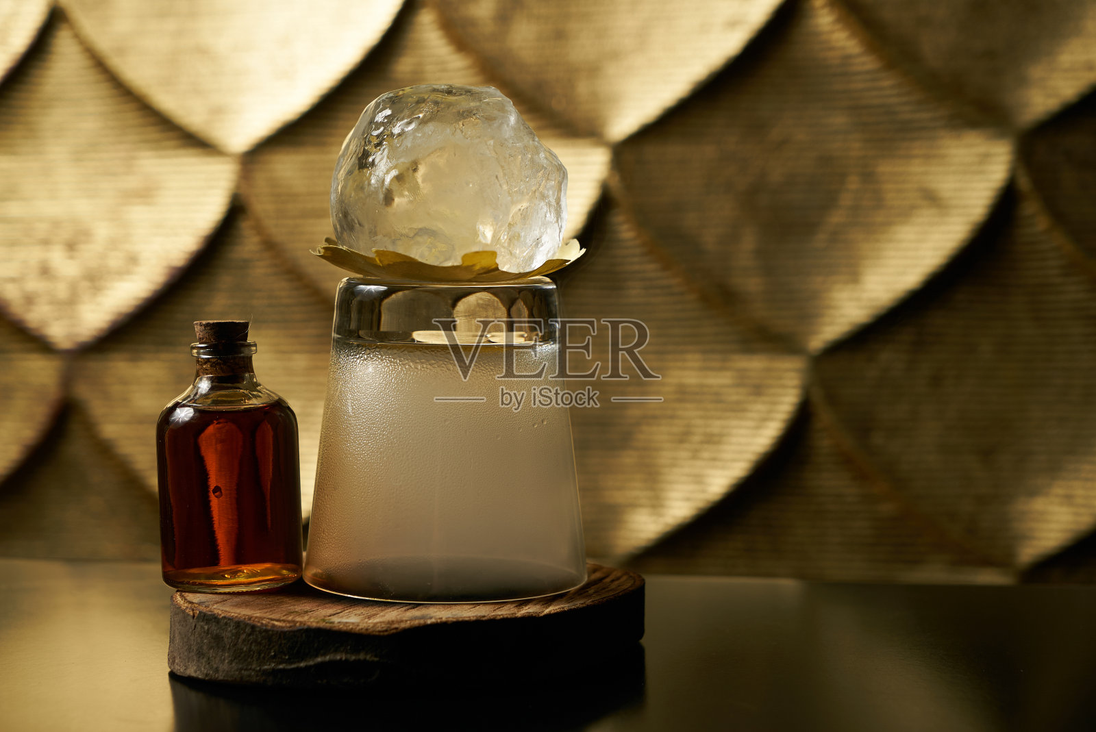 一个新鲜的品牌酒精鸡尾酒冰和干邑白兰地的特写，和在一个木制桦木吧台上的威士忌玻璃杯吸烟。照片摄影图片