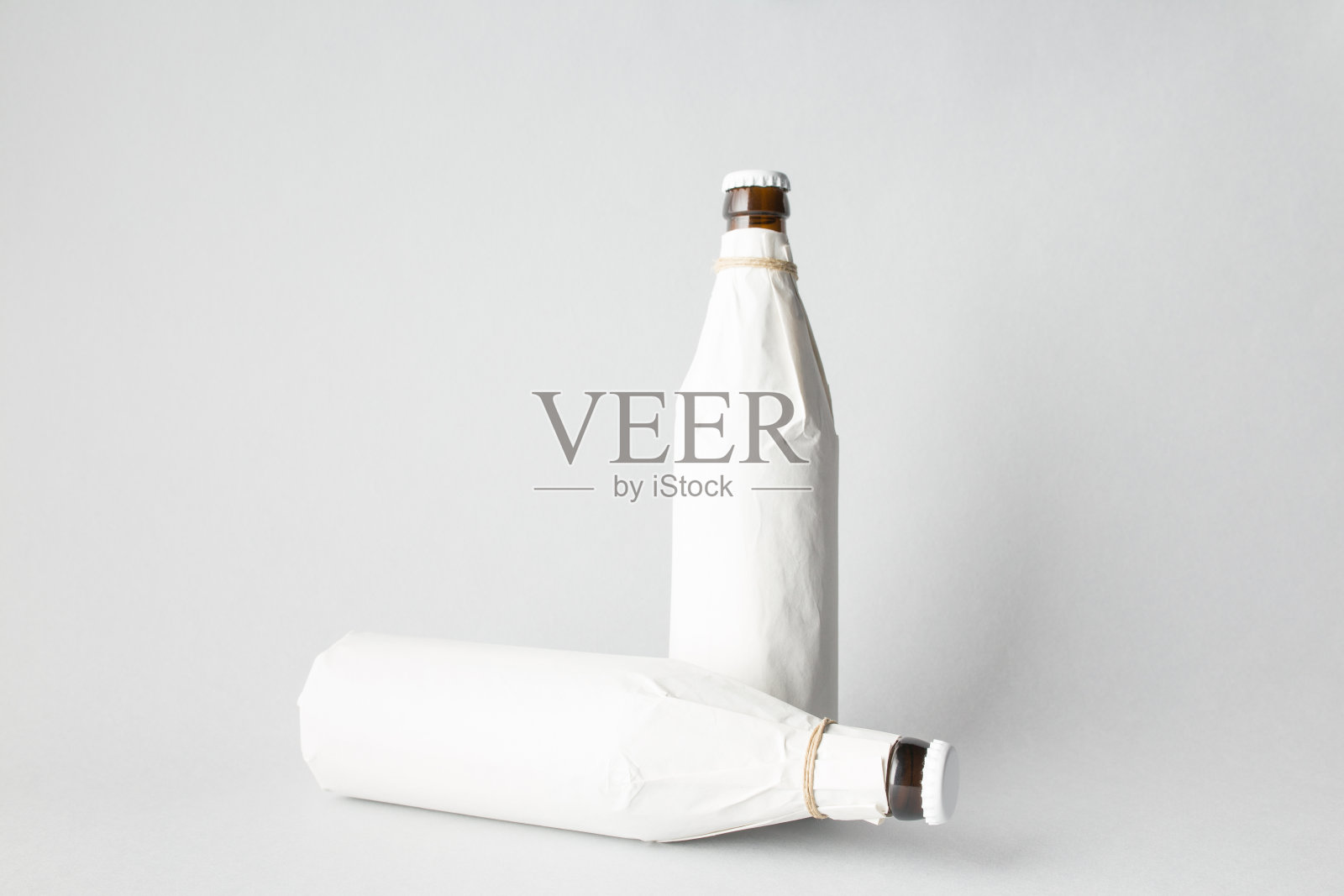 由两个瓶子组成:一个立着，另一个倒着照片摄影图片