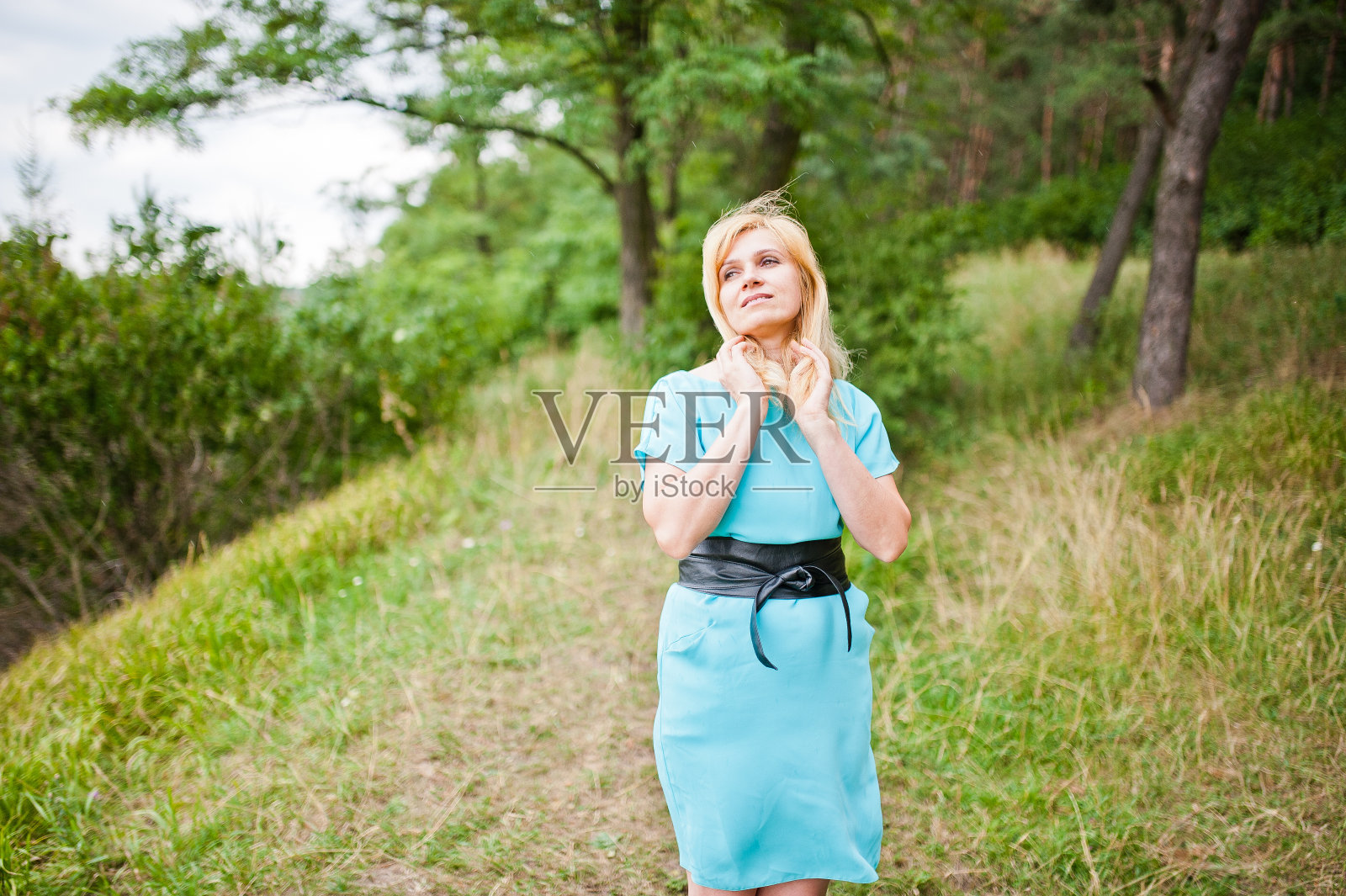 成年金发女子在松树林摆姿势照片摄影图片