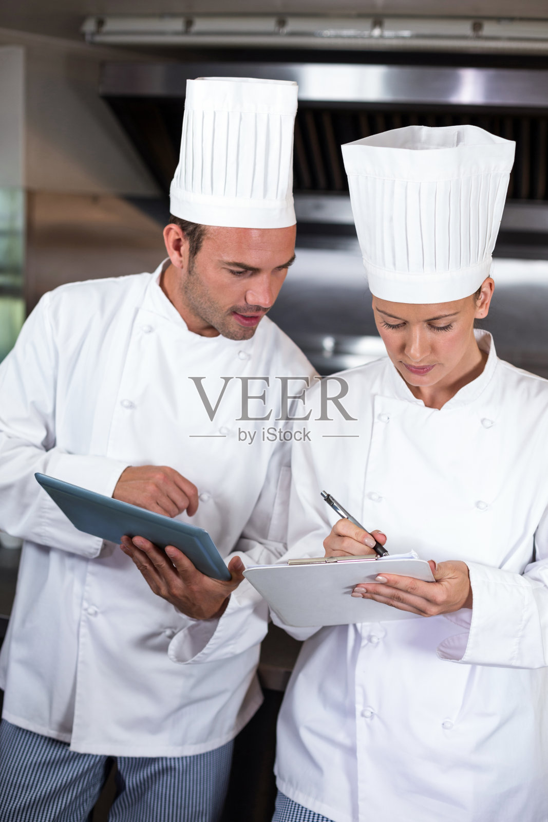 厨房里专注的厨师拿着写字板照片摄影图片