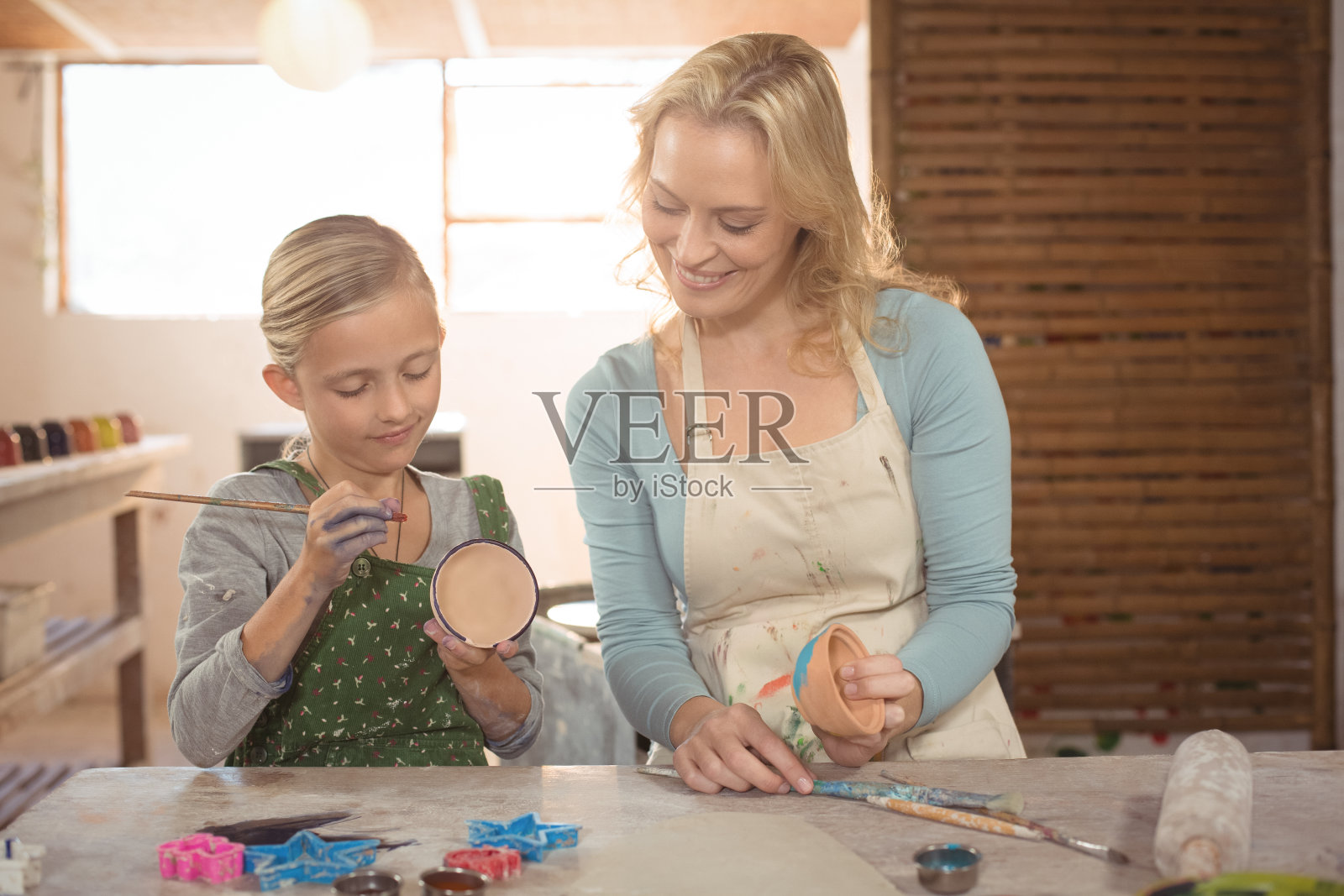 女陶工协助女孩绘画照片摄影图片