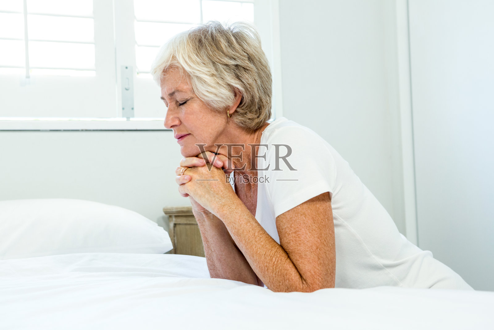 在家里祈祷的老年妇女照片摄影图片