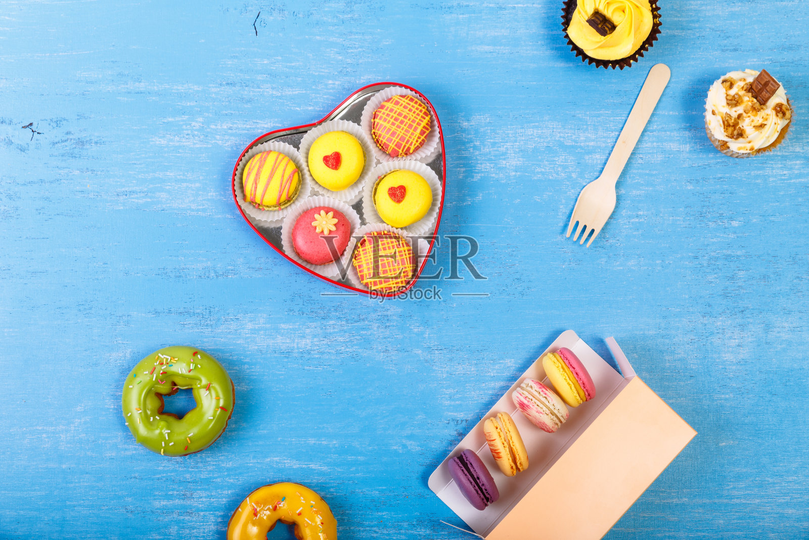 釉面甜甜圈，马卡龙和纸杯蛋糕。甜点。照片摄影图片