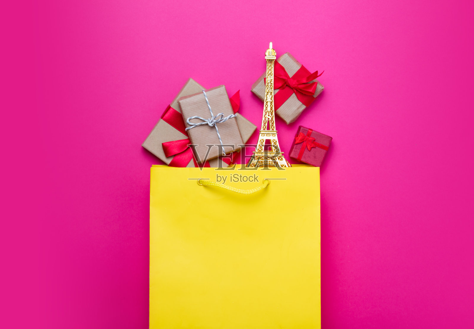 可爱的礼物和美丽的埃菲尔铁塔造型的玩具购物袋在奇妙的粉红色背景照片摄影图片