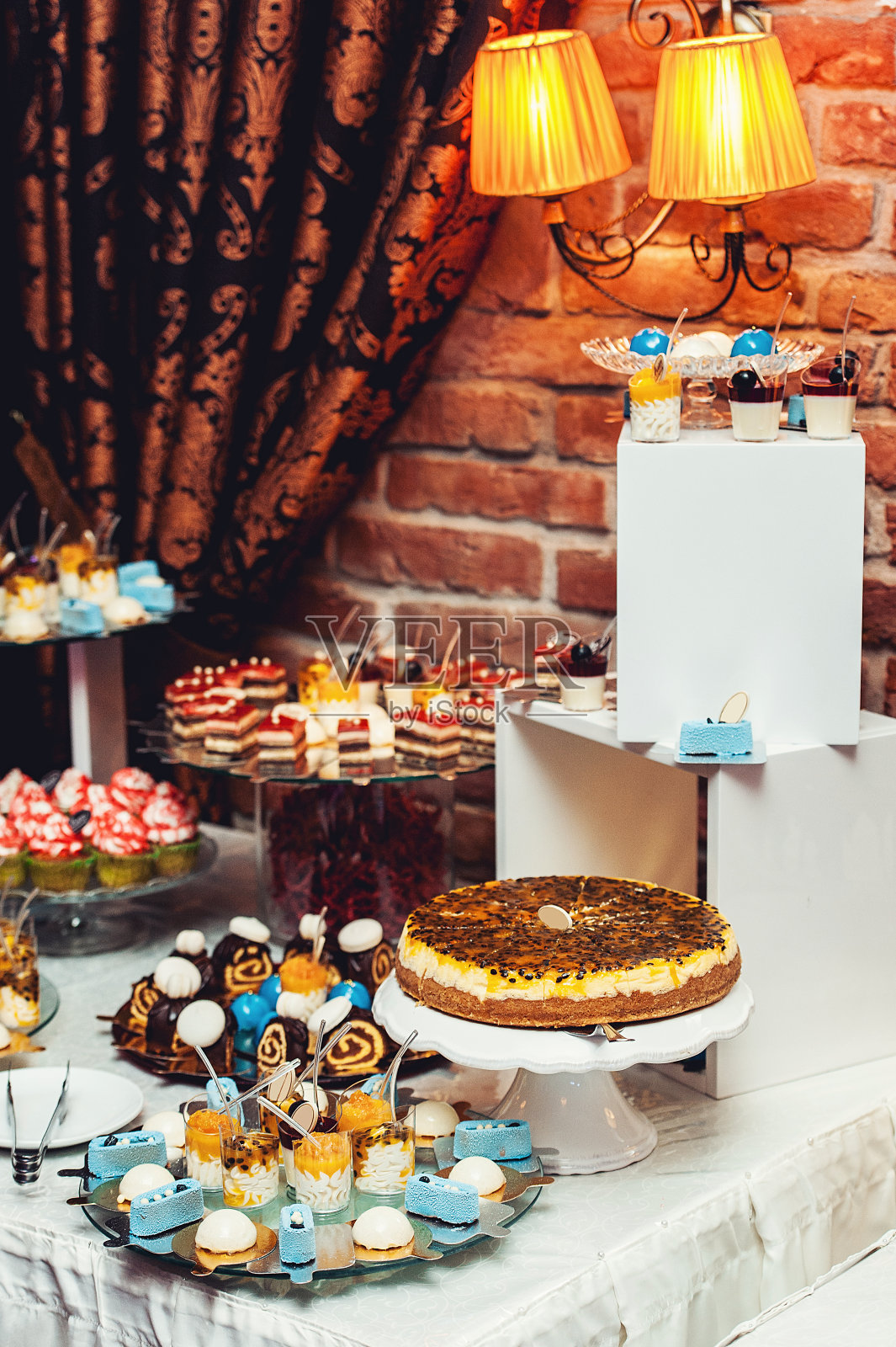 蓝白糖果镀金纸上的婚礼糖果棒。背景上的砖墙照片摄影图片