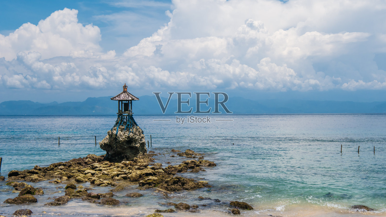 可爱的寺庙在海岸上的努沙佩尼达与戏剧性的云巴厘岛，印度尼西亚照片摄影图片