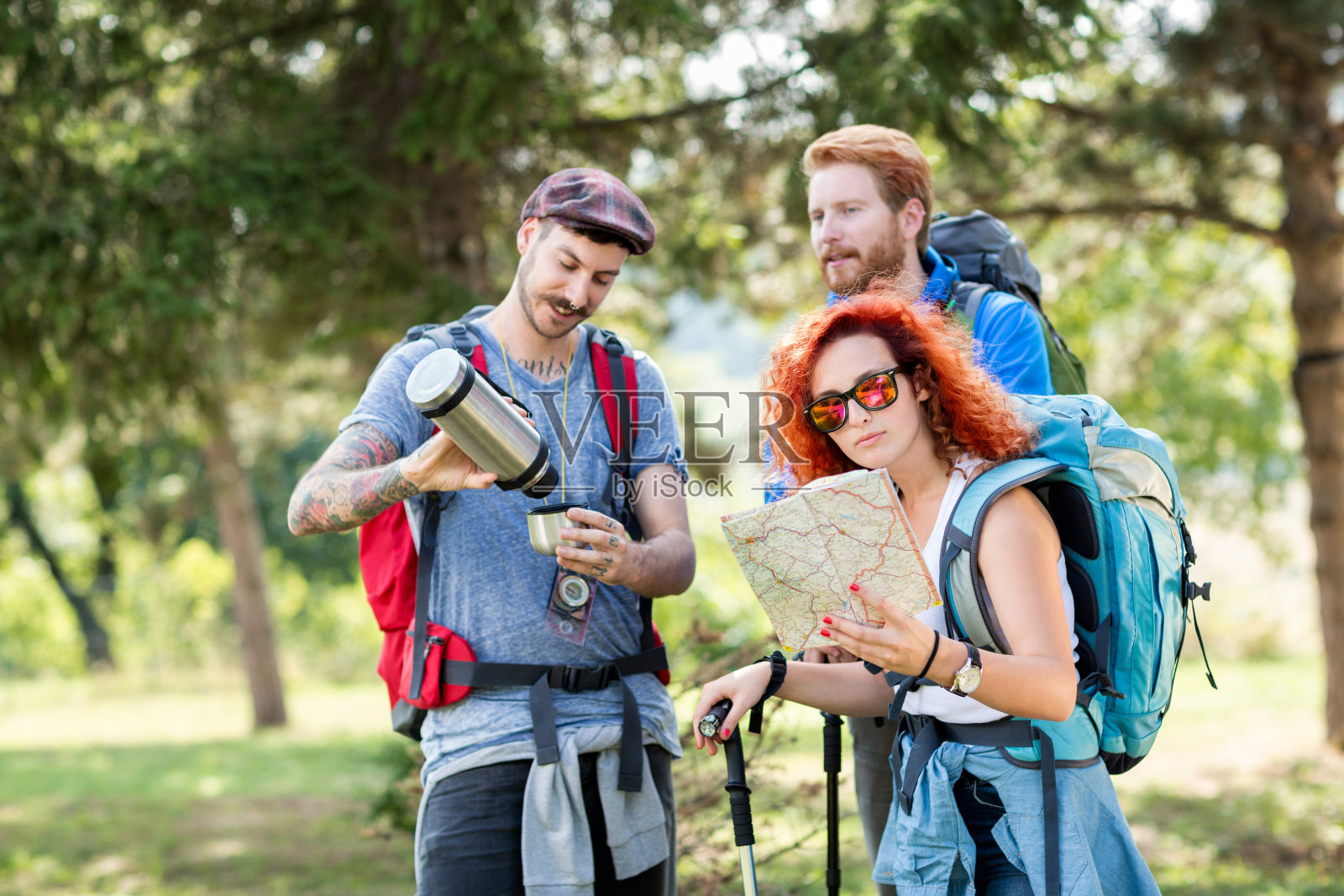 运动员背着背包在森林里用手杖徒步旅行照片摄影图片