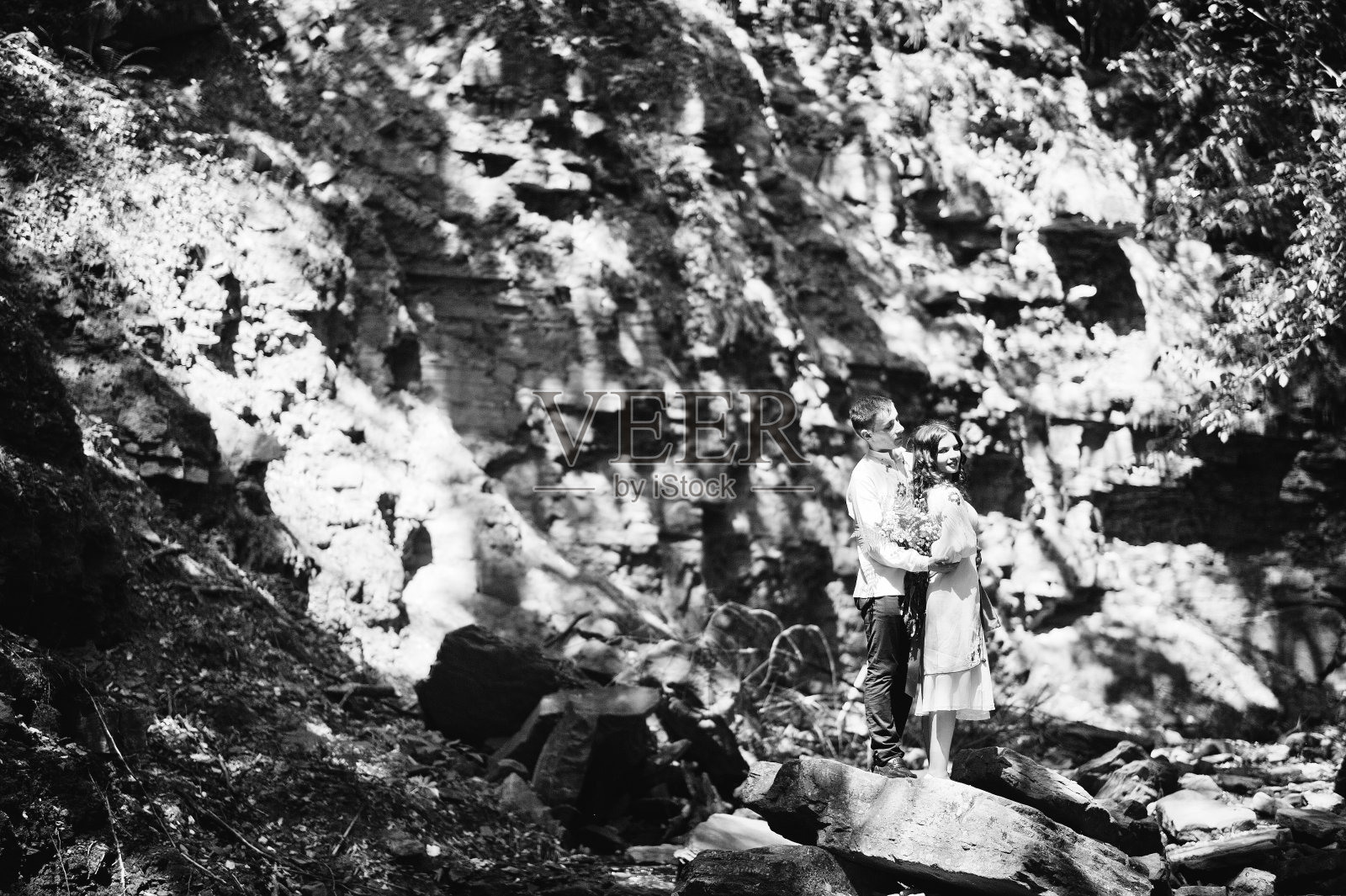 这是一对穿着乌克兰民族服装的情侣的爱情故事。在木头上加上石头照片摄影图片