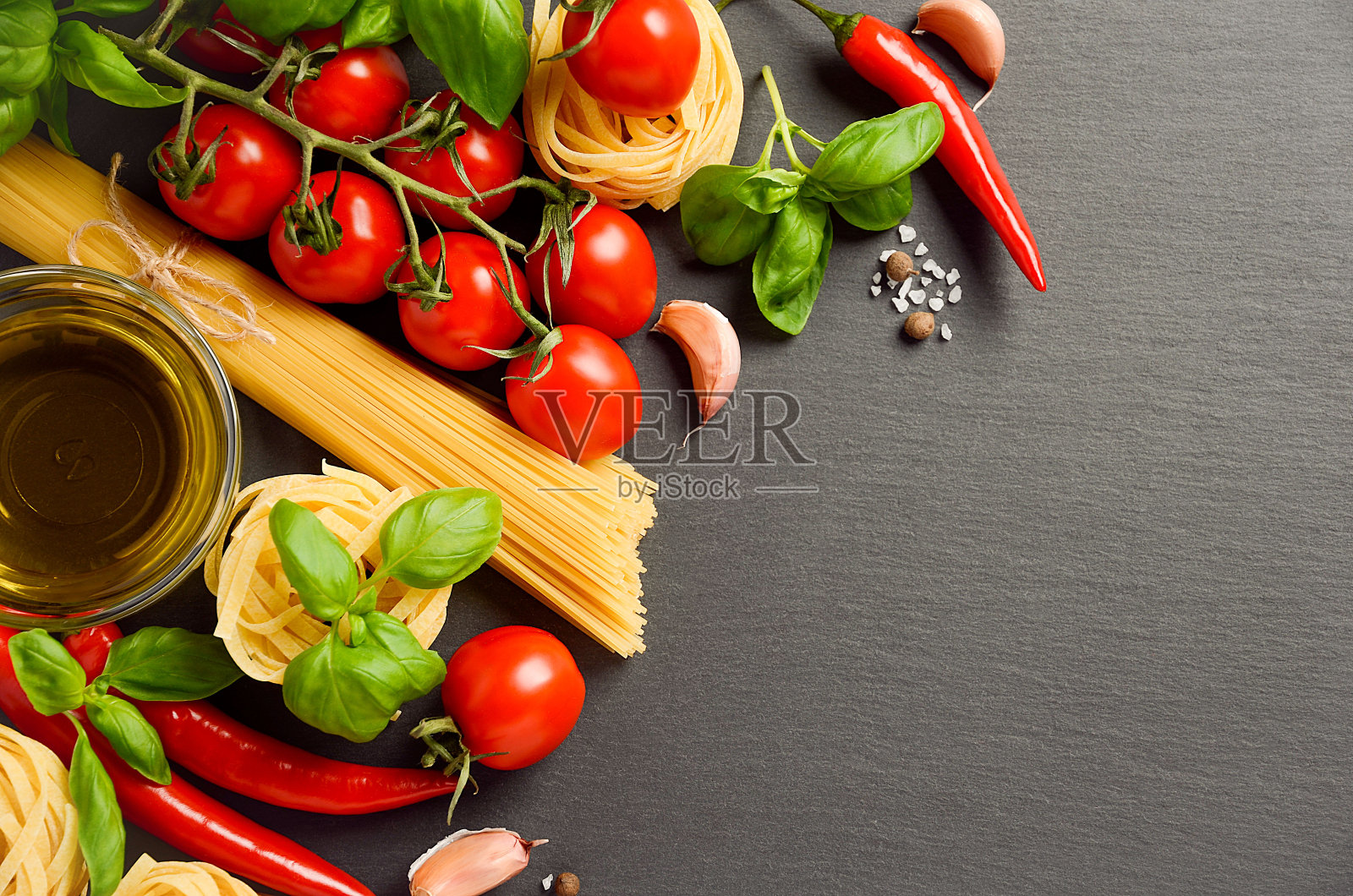 黑色背景为意大利面食、蔬菜、香草和香料照片摄影图片