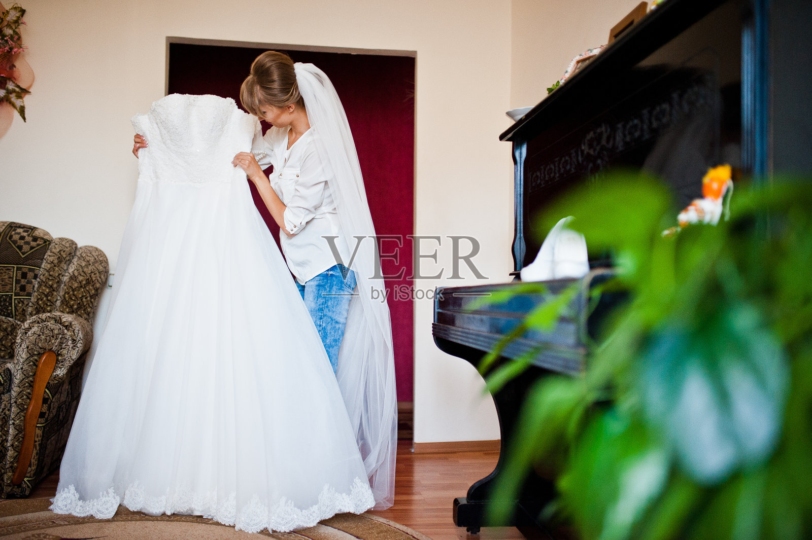 年轻快乐的新娘看着她的婚纱照片摄影图片