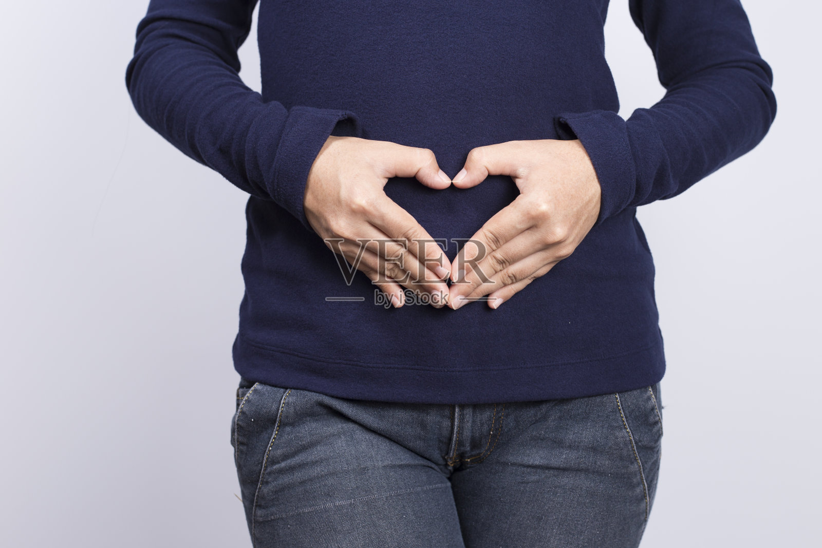 在腹部形成心形的女人照片摄影图片