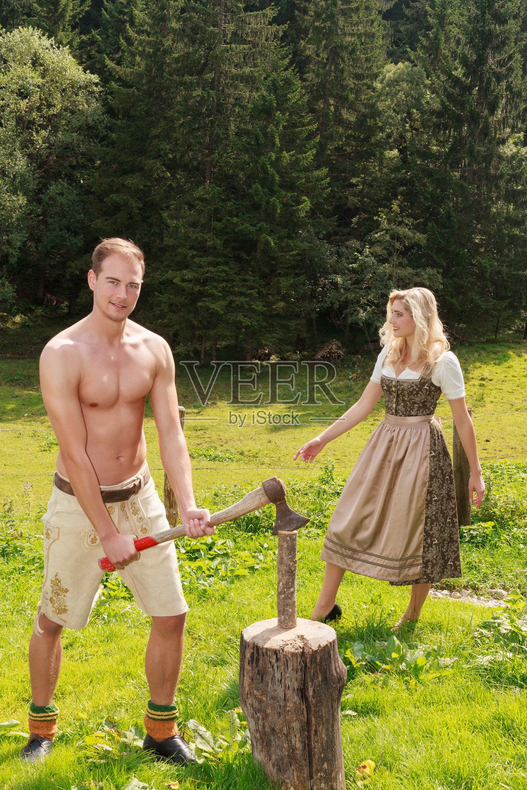 一个年轻人在夏季的牧场上砍柴照片摄影图片