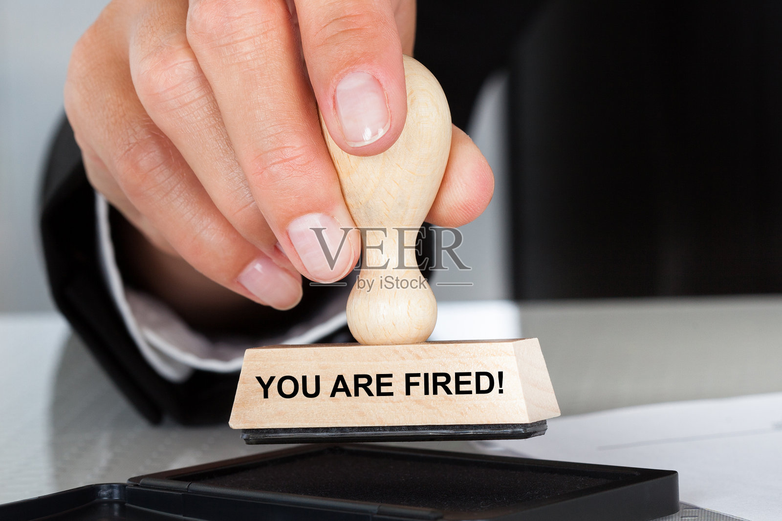 手握橡皮图章和你被解雇的标志照片摄影图片